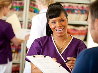 image of front desk assistant helping person fill out paperwork. image of front desk assistant helping person fill out paperwork.